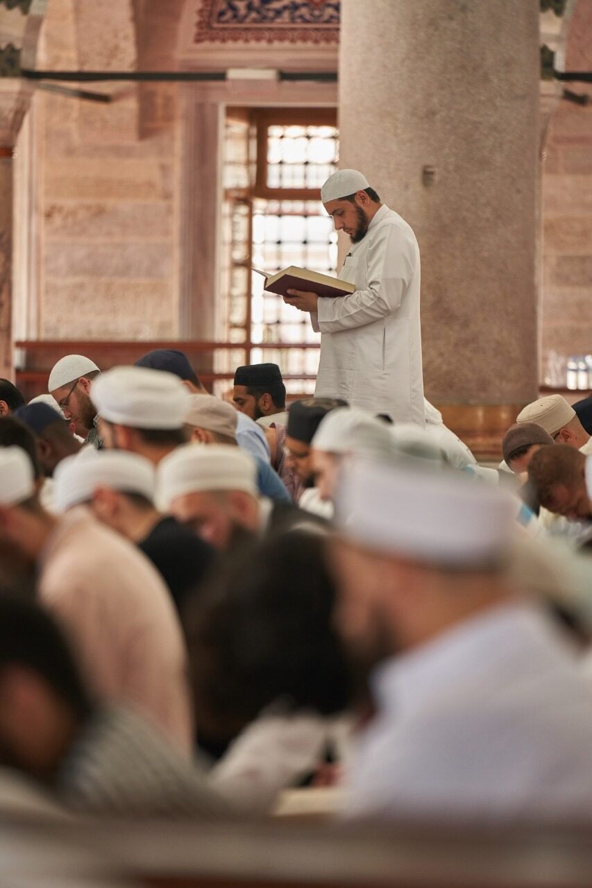 A student standing in recitation among the congregation